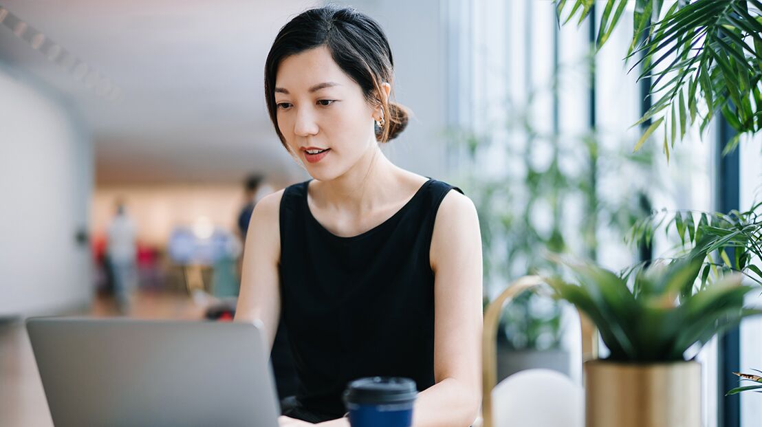 Frau recherchiert am Laptop in Flur