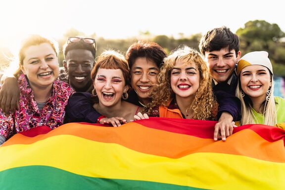 queere Studierende mit bunter Flagge