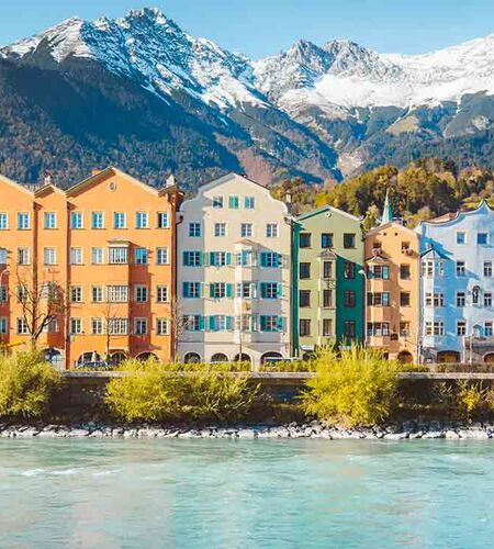 Blick vom Wasser auf die bekannte, bunte Häuserfront des Innsbrucker Stadtteils Mariahilf, Österreich.