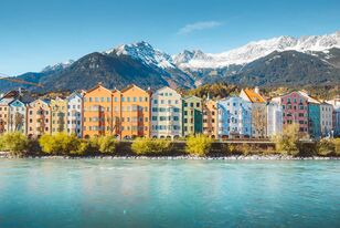 Blick vom Wasser auf die bekannte, bunte Häuserfront des Innsbrucker Stadtteils Mariahilf, Österreich.