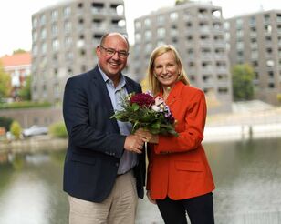 Prof. Dr. Lars Binckebanck überreicht Blumenstrauß an Prof. Dr. Irina Kummert am Osterbekkanal.