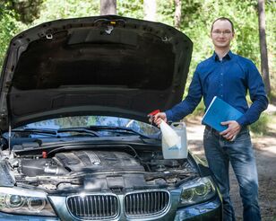 Stefan Nahs, Absolvent des Bachelors Wirtschaftsingenieurwesen der HFH, vor Auto mit geöffneter Motorhaube.