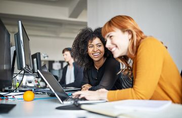 Zwei Frauen lachend vor Notebook