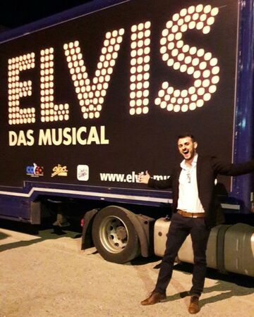 Junger Mann vor Truck mit Aufschrift Elvis - Das Musical