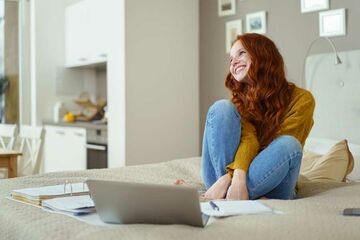 Eine Studierende lernt zu Hause auf dem Bett