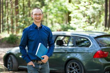 HFH-Absolvent Stefan Nahs mit Bachelorarbeit vor PKW.