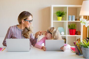 Studierende Mutter mit Kind vor Laptops